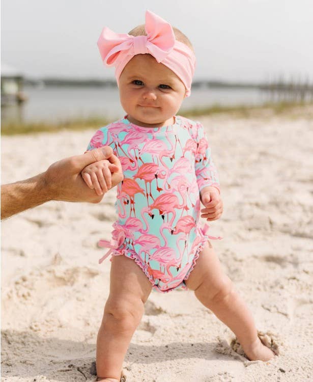 infant wearing flamingo designed swim suit